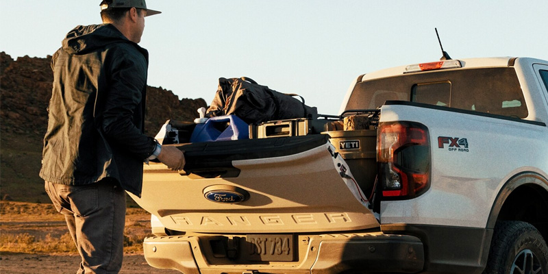 A used 2024 Ford Ranger with a filled trunk and a driver closing the tailgate in San Antonio, TX